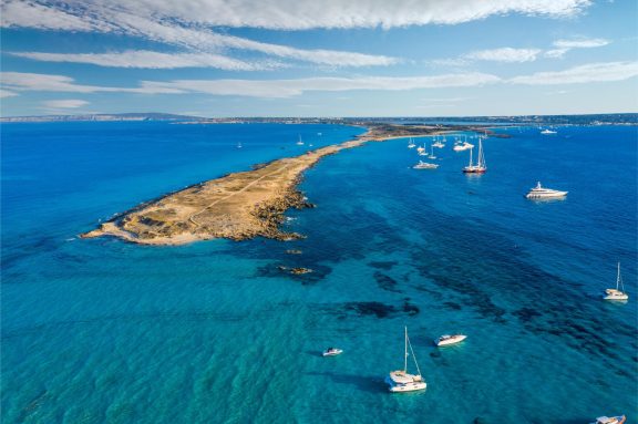 Aerial view over the clear waters of Formentera and yachts on anchor